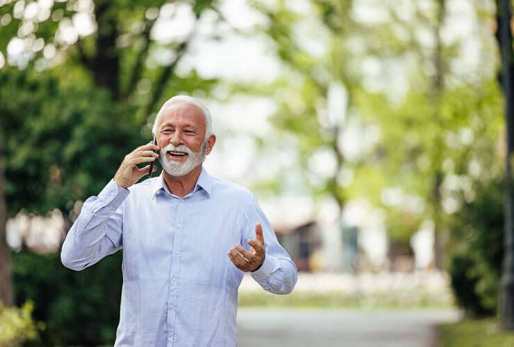 Man walking in the outdoors talking on his mobile device