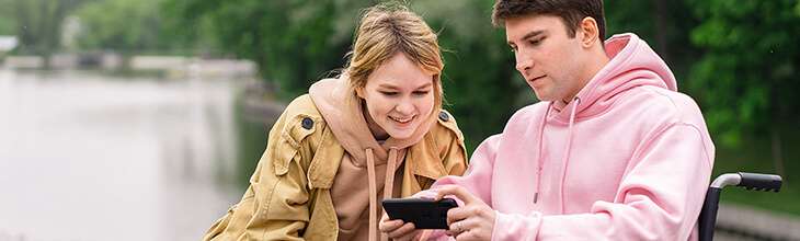 Couple looks at mobile phone outdoors