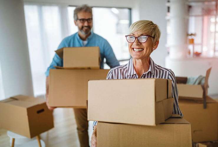 A couple moves boxes in their new house